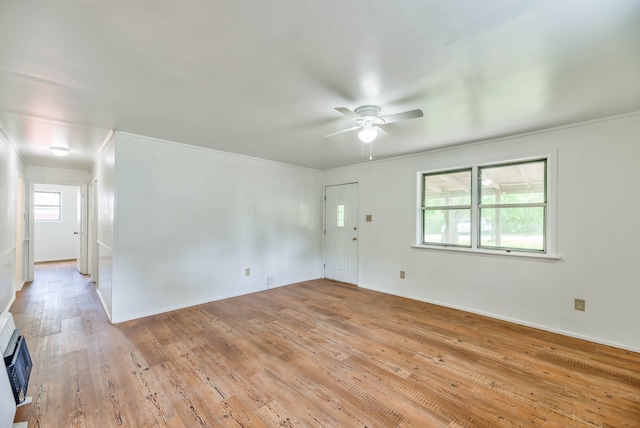 spare room featuring heating unit, ceiling fan, and light hardwood / wood-style flooring