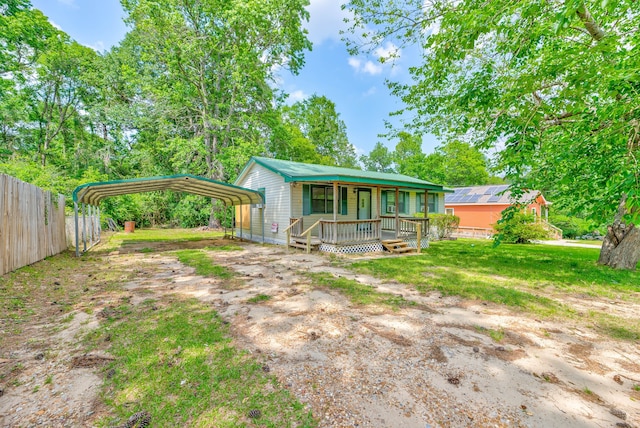 exterior space featuring a carport, covered porch, and a lawn