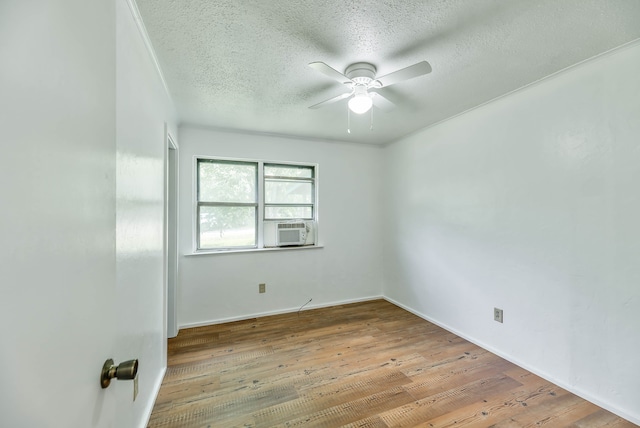 unfurnished room featuring cooling unit, ceiling fan, light hardwood / wood-style floors, and a textured ceiling