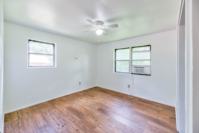 spare room featuring hardwood / wood-style flooring, cooling unit, and ceiling fan