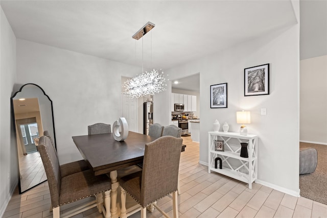 dining area with a notable chandelier and light hardwood / wood-style floors