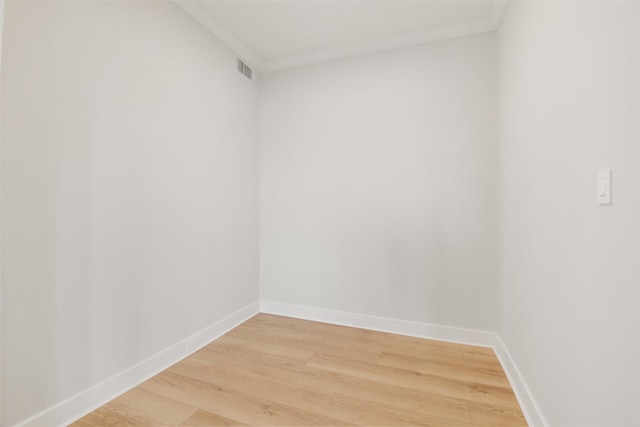 unfurnished room featuring baseboards, crown molding, visible vents, and wood finished floors