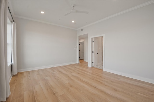 spare room with light wood-style floors, crown molding, and baseboards