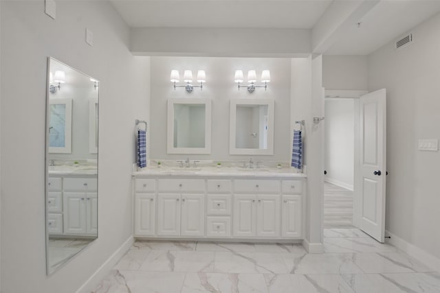 full bath featuring marble finish floor, double vanity, visible vents, and baseboards