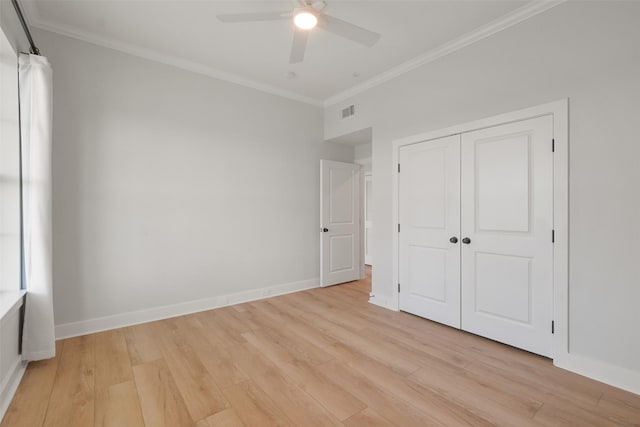 unfurnished bedroom featuring light wood-style flooring, visible vents, baseboards, and crown molding