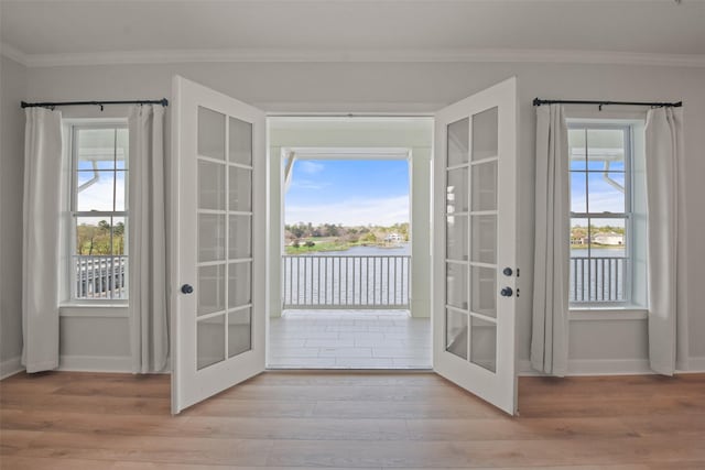 doorway to outside featuring ornamental molding, french doors, and light wood-style floors