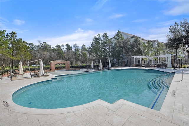 community pool with a patio and a pergola