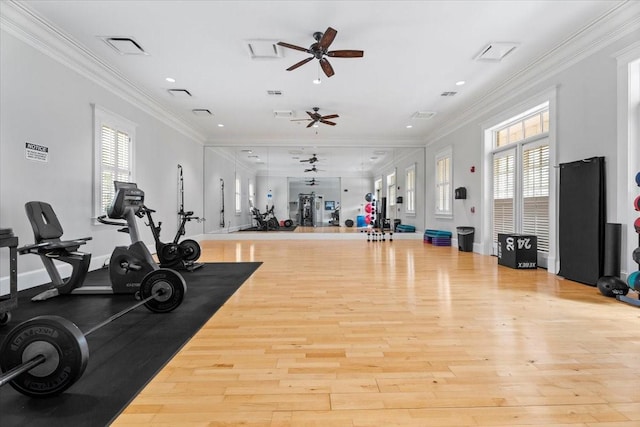 exercise room with plenty of natural light, ornamental molding, and light wood-type flooring