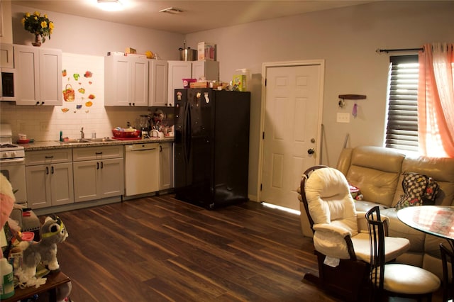 kitchen with white appliances, dark hardwood / wood-style floors, sink, and white cabinets