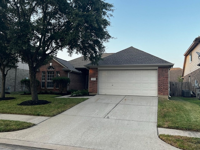 ranch-style house with cooling unit, a garage, and a front yard