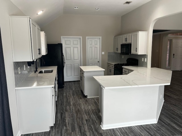 kitchen featuring sink, white cabinetry, black appliances, a kitchen island, and kitchen peninsula