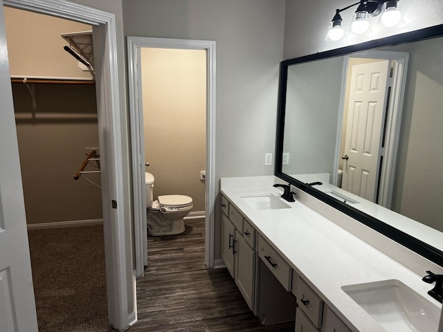 bathroom with hardwood / wood-style flooring, vanity, and toilet