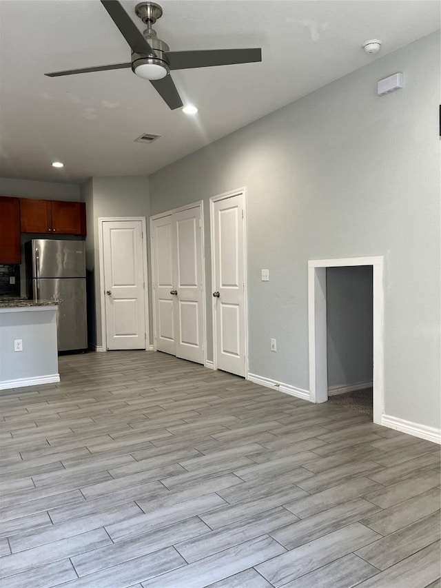 interior space with ceiling fan, stainless steel refrigerator, and light hardwood / wood-style floors