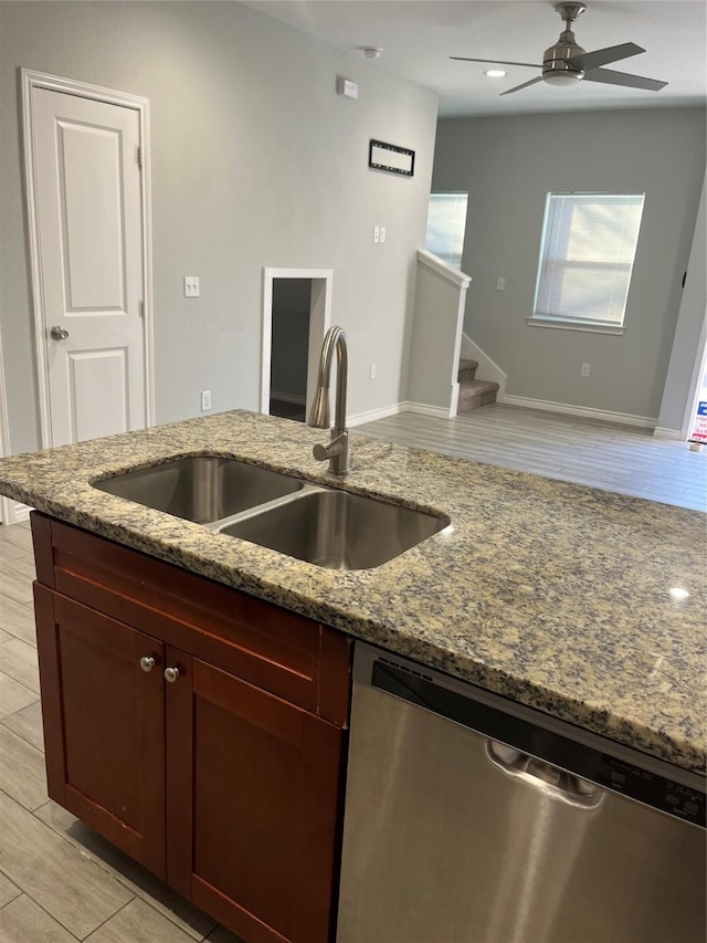 kitchen with sink, ceiling fan, dishwasher, stone countertops, and light wood-type flooring