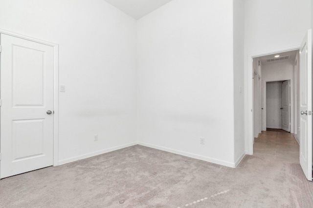 unfurnished room featuring light colored carpet