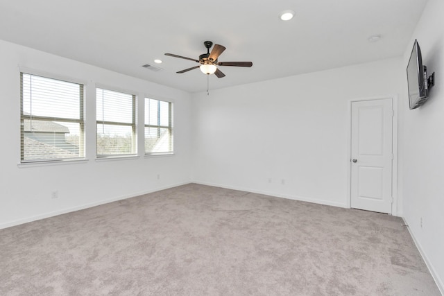 spare room featuring light colored carpet and ceiling fan