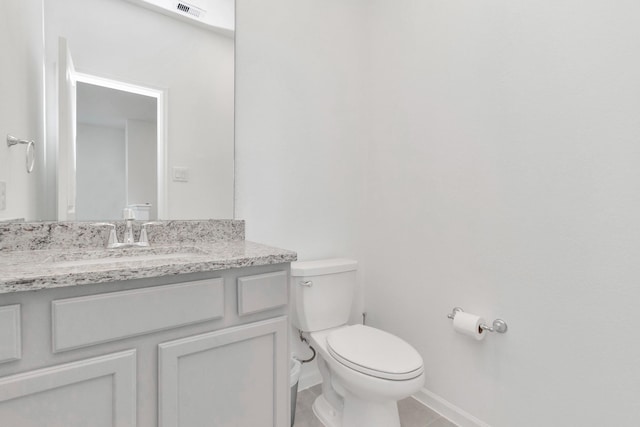 bathroom featuring tile patterned floors, vanity, and toilet