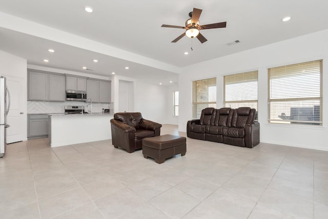 tiled living room with sink and ceiling fan