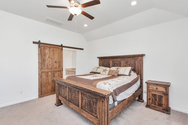 bedroom featuring ceiling fan, lofted ceiling, a barn door, and light carpet