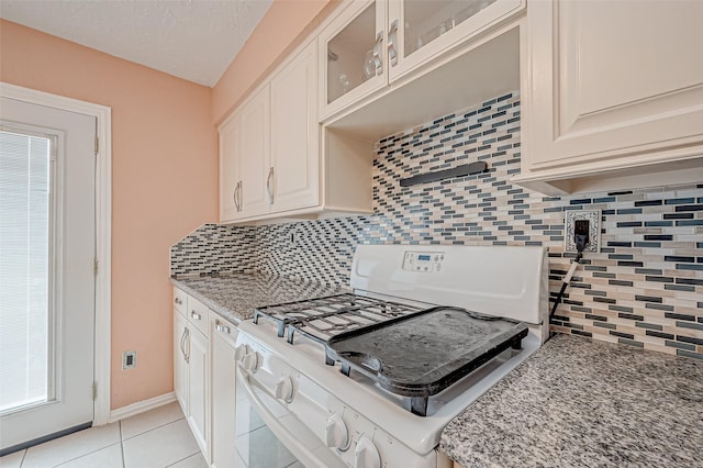 kitchen with white cabinetry, white gas range, light tile patterned floors, and light stone counters