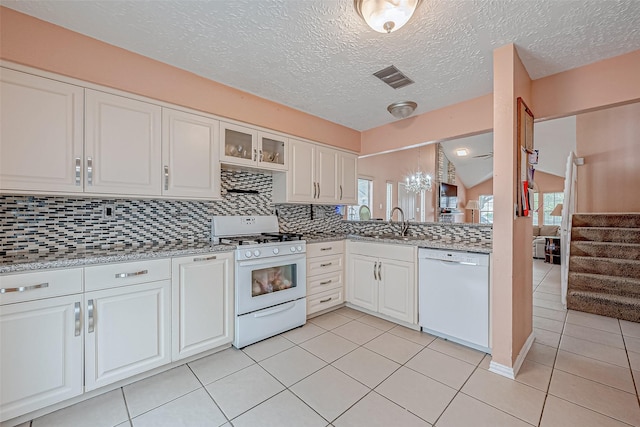 kitchen with sink, white appliances, light tile patterned floors, white cabinetry, and backsplash