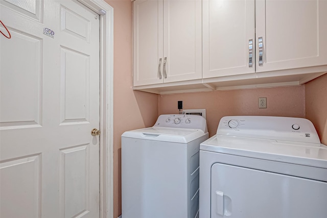 washroom featuring cabinets and washing machine and clothes dryer