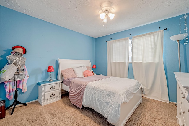 carpeted bedroom with ceiling fan and a textured ceiling