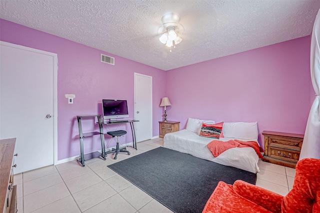 tiled bedroom featuring ceiling fan and a textured ceiling