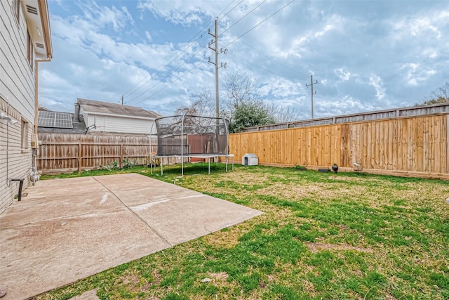 view of yard featuring a trampoline and a patio