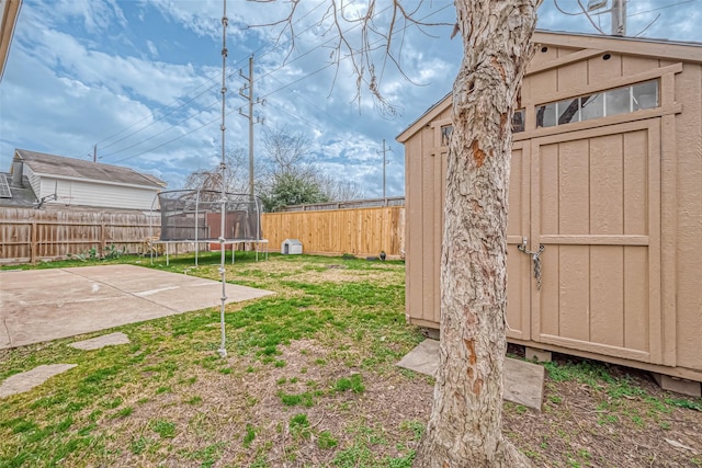 view of yard with a patio, a storage unit, and a trampoline