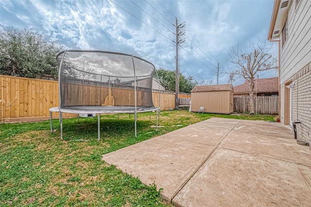 view of yard with a trampoline, a patio area, and a storage unit