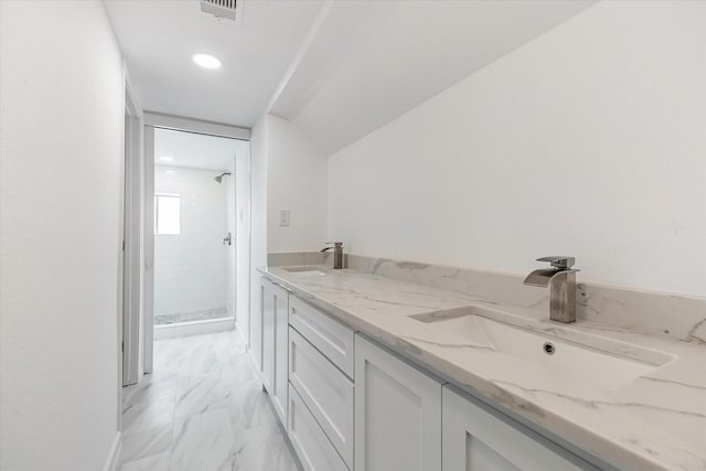 bathroom with vanity and a tile shower