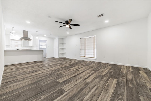 unfurnished living room with dark wood-type flooring and ceiling fan