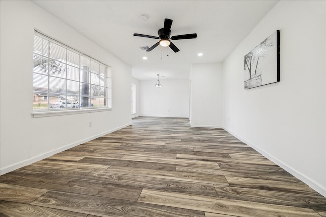 empty room featuring dark wood-type flooring and ceiling fan