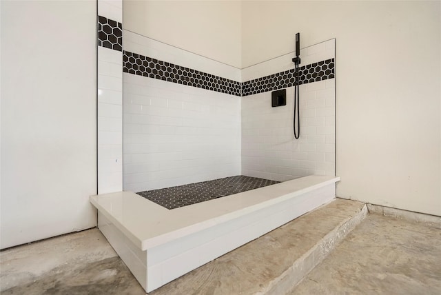 bathroom featuring unfinished concrete flooring and tiled shower