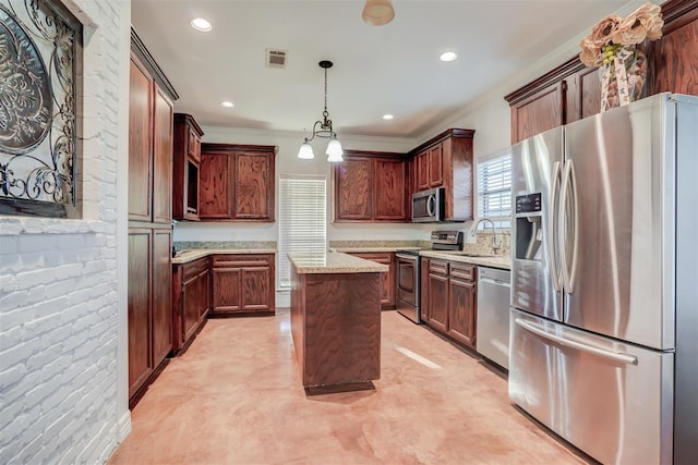 kitchen with light stone countertops, a center island, ornamental molding, visible vents, and appliances with stainless steel finishes