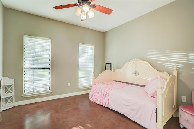 bedroom featuring finished concrete floors, baseboards, and a ceiling fan
