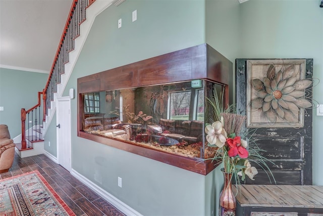 interior space with baseboards, ornamental molding, and wood finish floors