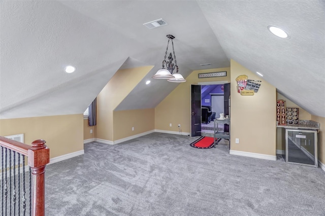 bonus room featuring carpet flooring, visible vents, baseboards, and lofted ceiling