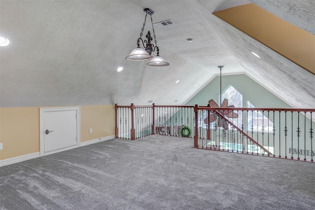 additional living space featuring carpet, a textured ceiling, and vaulted ceiling