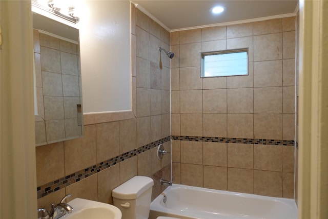 full bathroom featuring sink, tile walls, tiled shower / bath combo, toilet, and crown molding