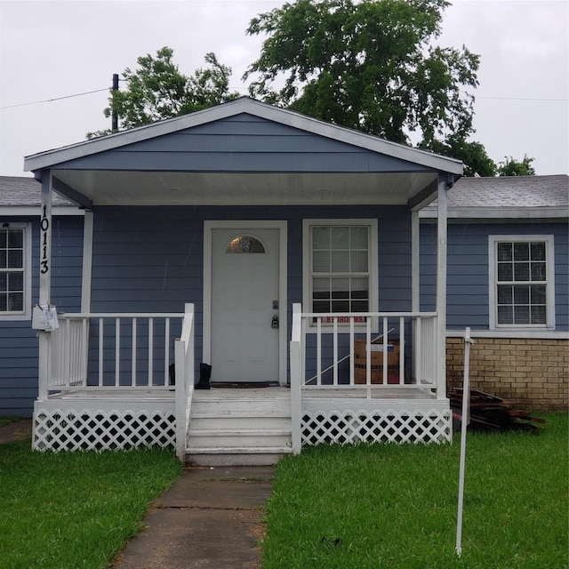 bungalow-style house featuring a porch and a front lawn