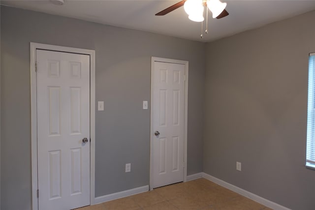 unfurnished bedroom with light tile patterned flooring and ceiling fan