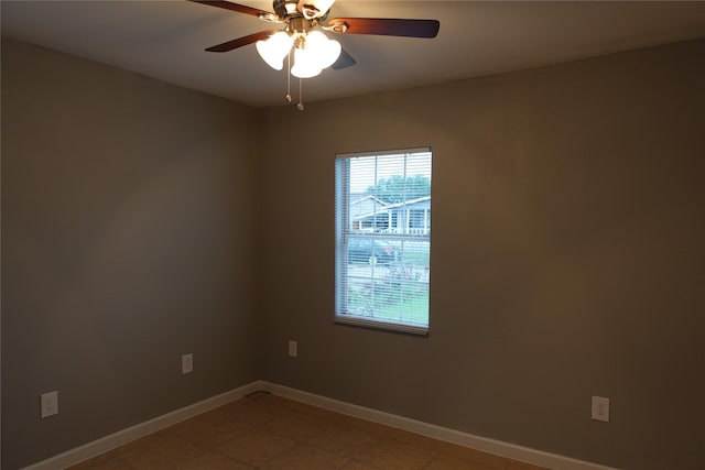 empty room with ceiling fan and light tile patterned floors