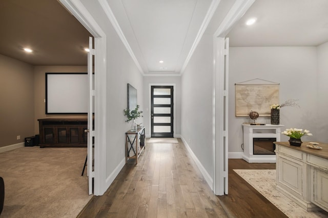 foyer featuring ornamental molding and light hardwood / wood-style flooring