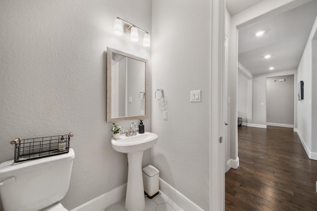 bathroom with hardwood / wood-style floors and toilet