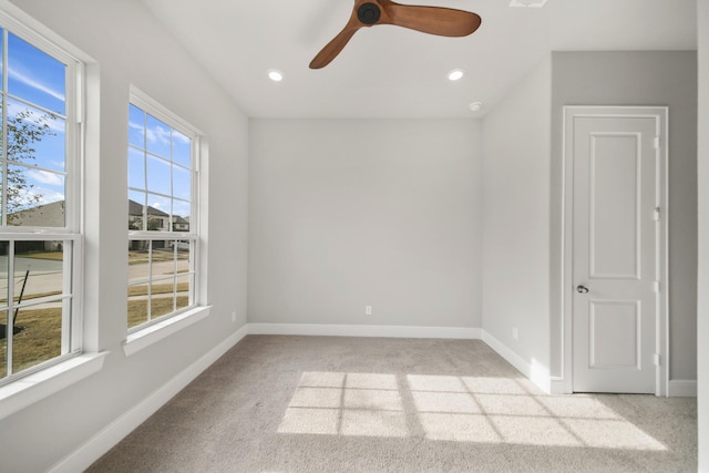 spare room with ceiling fan and light carpet