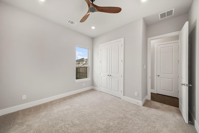 unfurnished bedroom with light colored carpet, ceiling fan, and a closet