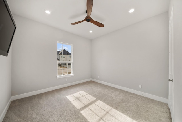 carpeted spare room featuring ceiling fan