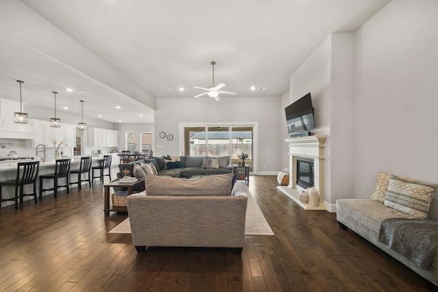 living room with ceiling fan and dark hardwood / wood-style flooring